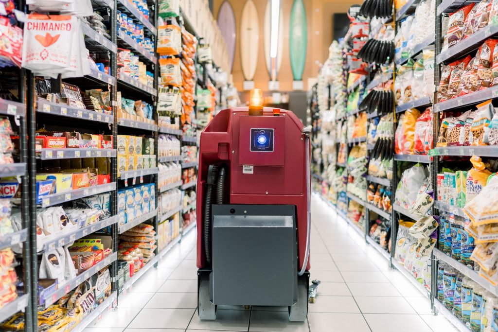 Màquina fregadora automàtica en un passadís d'un supermercat
