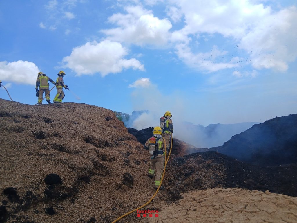 Els Bombers extingint el foc de les piles de material orgànic 